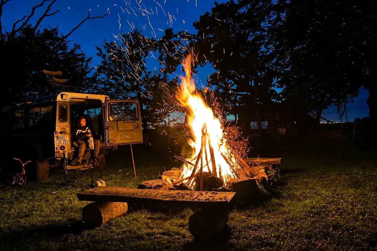 Loderndes Lagerfeuer in der Dämmerung auf der Hofwiese