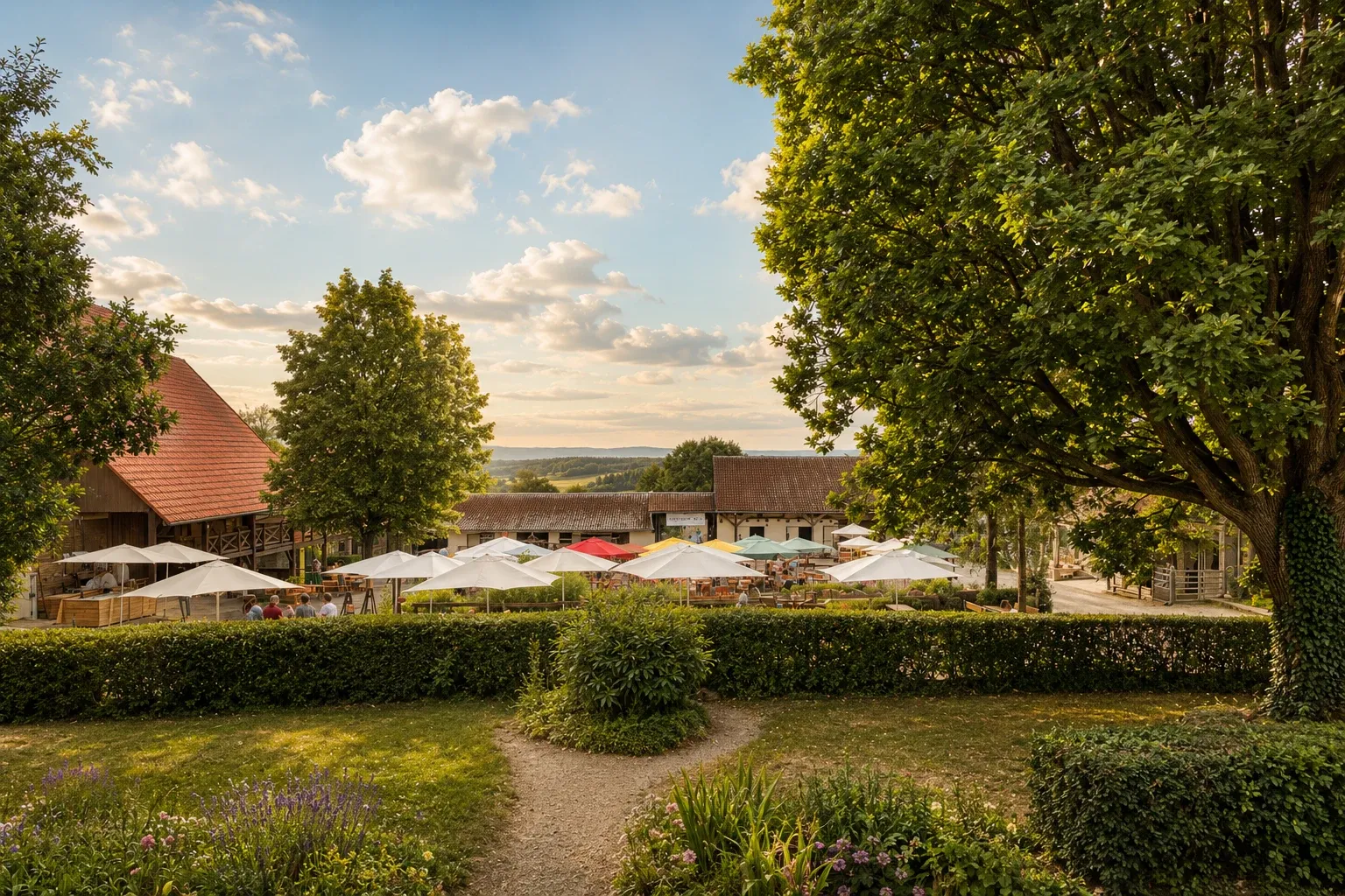 Sommerfest im Innenhof mit Sonnenschirmen, im Abendlicht hinter Hecke und Bäumen