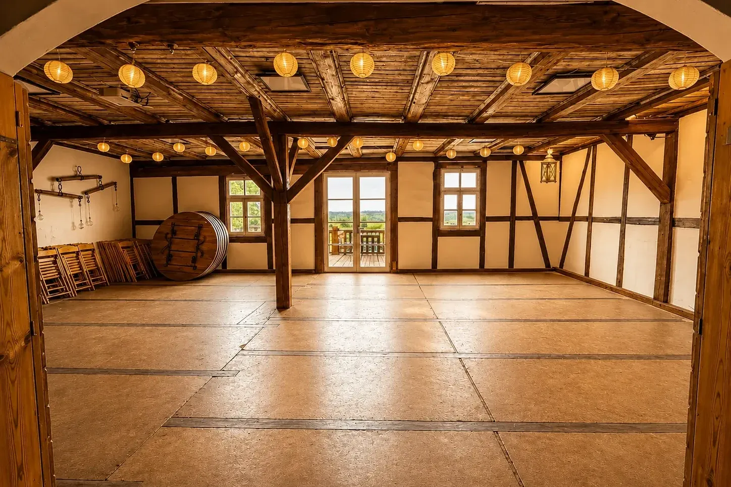Leerer historischer Saal mit Fachwerk, Holzbalkendecke und Lampions, Blick zur Terrasse