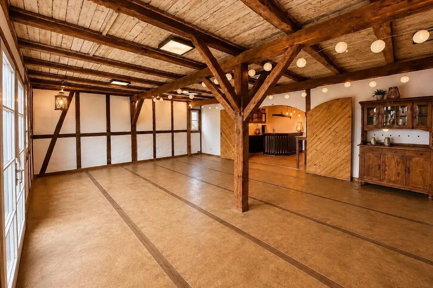 Leerer Saal mit Holzdecke und Theke im Hintergrund